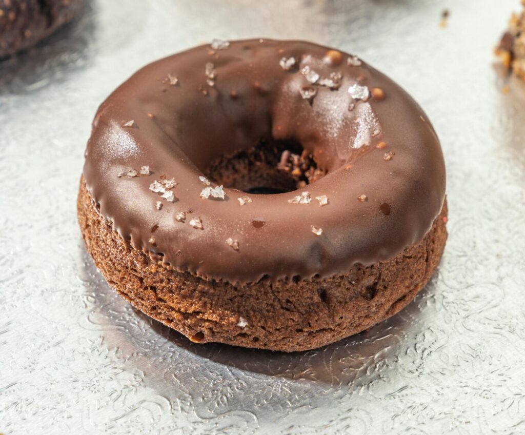 Mouthwatering chocolate donut topped with salt flakes, perfect for dessert lovers.